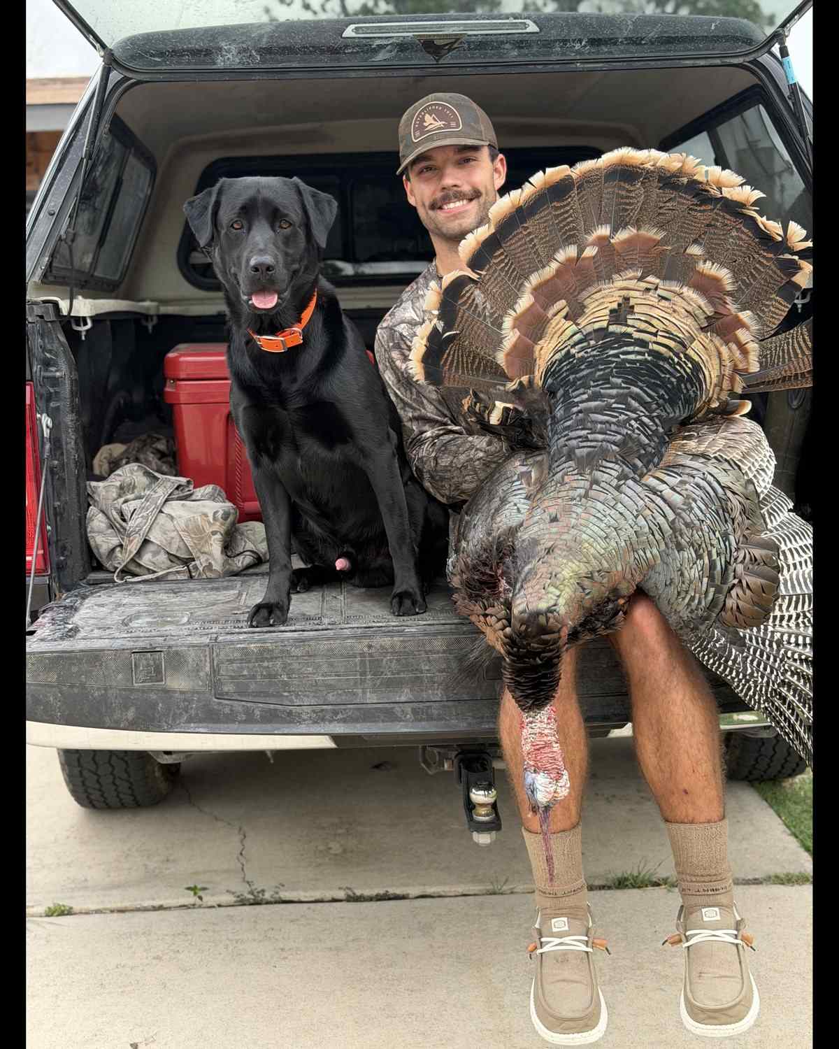 Ryan Watson on the tailgate with a Rio Grande tom and his Labrador