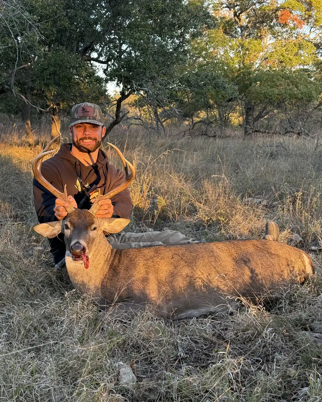 Hunter with a Hill Country whitetail at last light